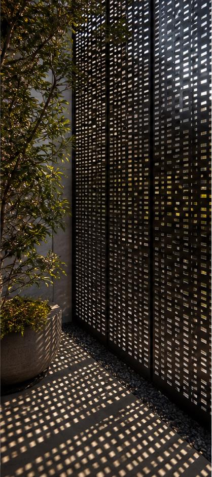 Perforated architectural screen casting patterned shadows