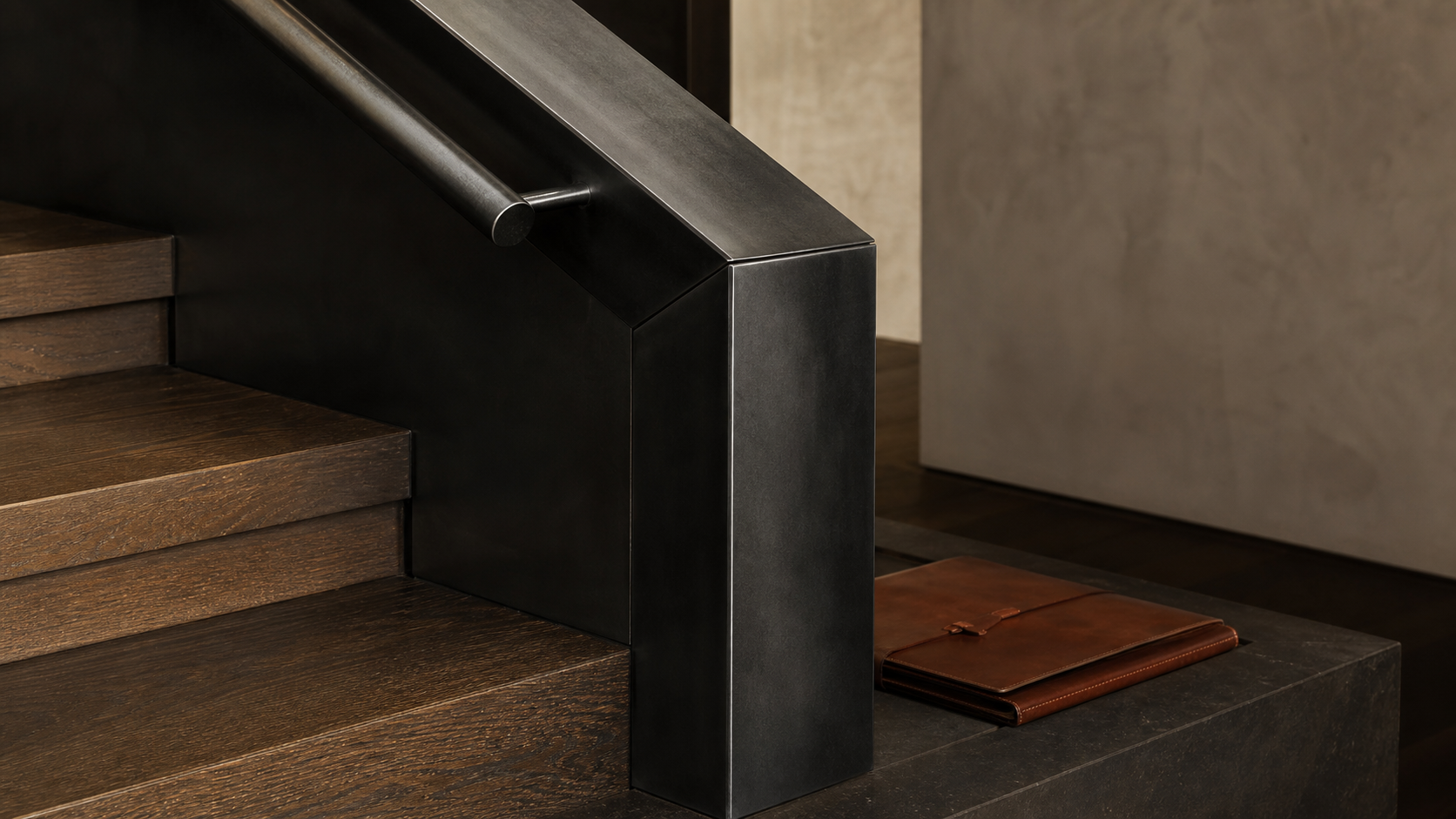 Blackened steel guard return meeting oak stair treads in a finished modern residence